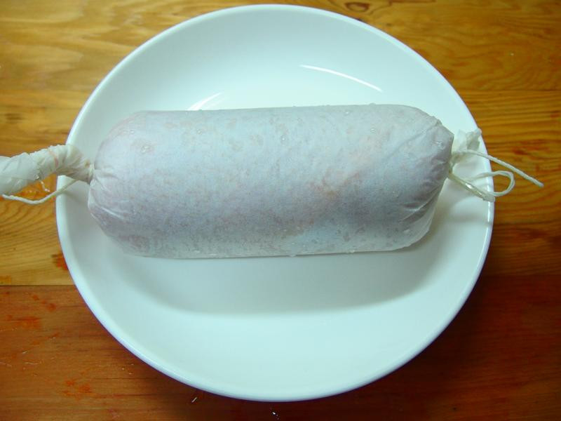 用料理纸把鸡肉卷起来~用点力卷得紧实些~肉才不会散开~二端用棉绳绑
