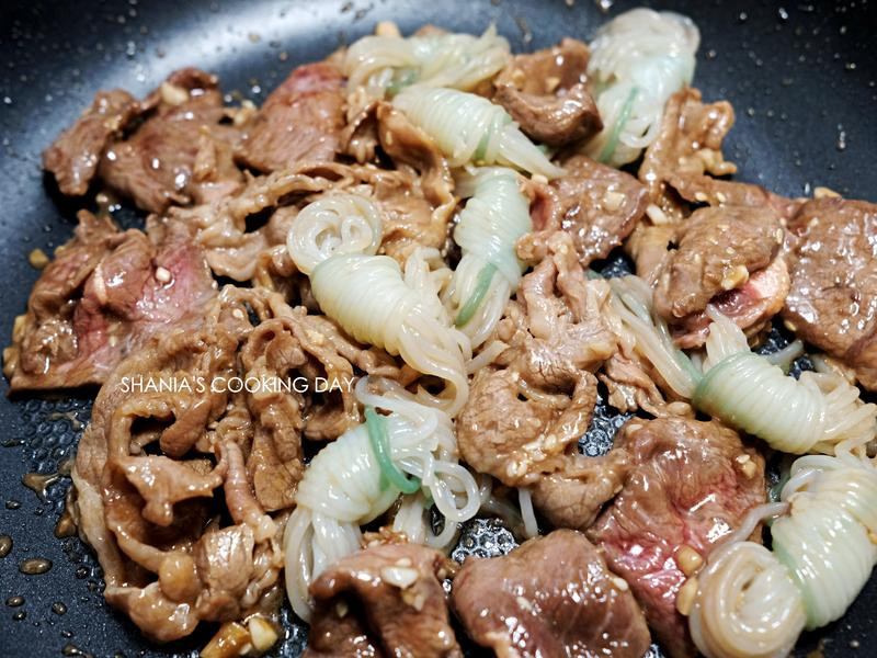 加入川烫过的蒟蒻丝与锅中肉片一起拌炒,并尽量让蒟蒻丝沾裹上腌酱.