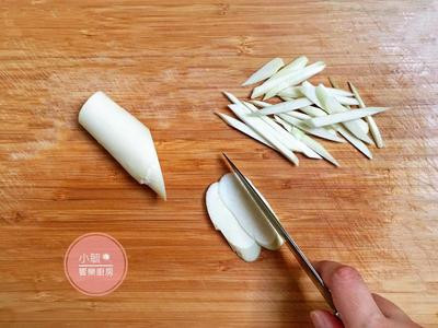 茭白筍將頂部撥除，先斜切成薄片狀，再切成絲。