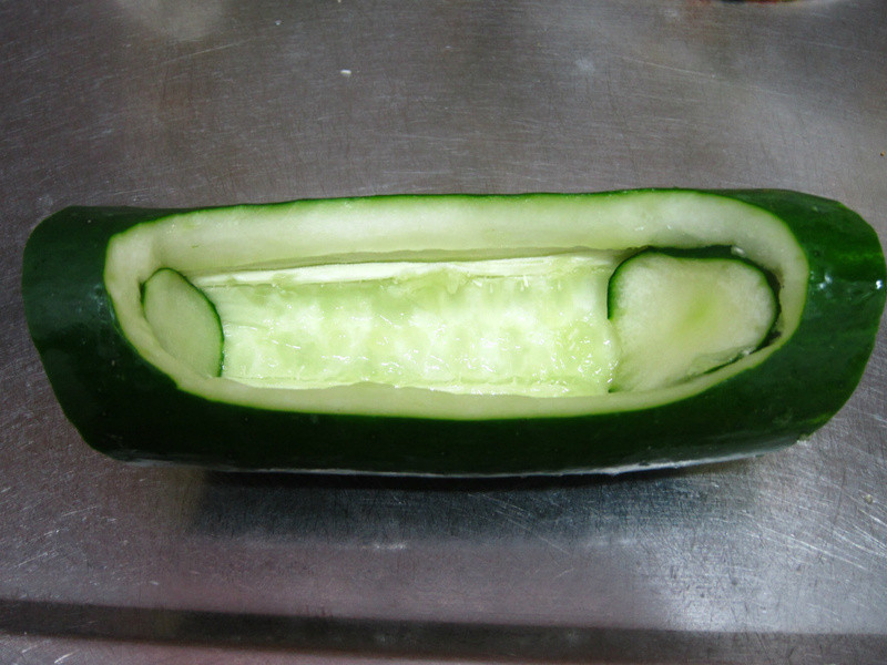 大黄瓜雕成船型,中间挖空,两旁内里用大黄瓜片盖住.